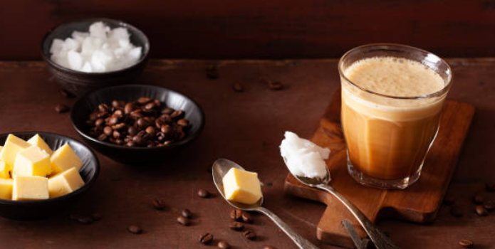 Ingredients in bulletproof coffee - coffee beans, butter, cream, glass of coffee