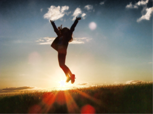 person jumping in the air, happy because she is achieving goals