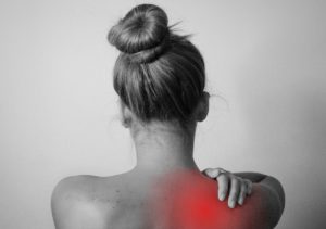 A large red mark is shown on a woman's upper back and shoulder area indicating the pain she is experiencing